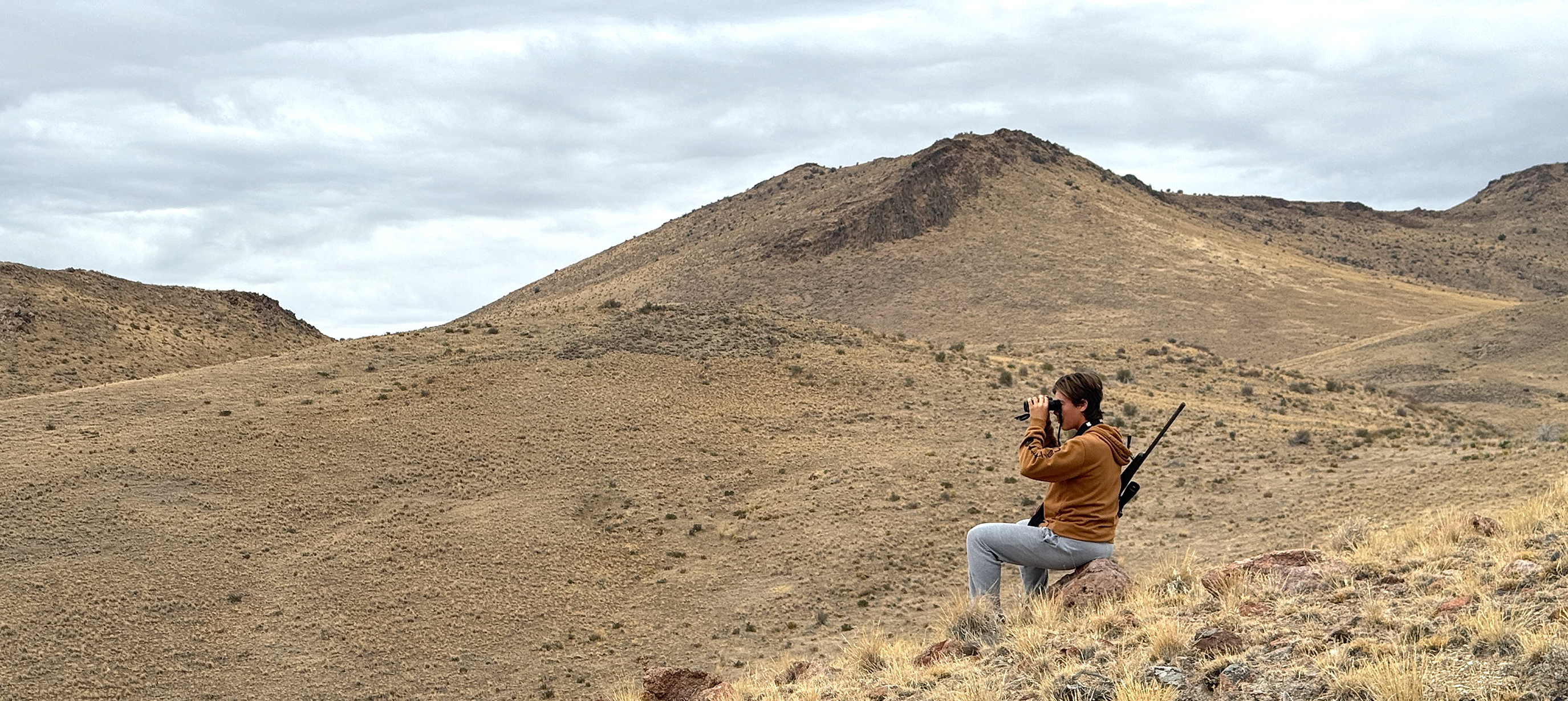 Youth glassing in the field while cloudy